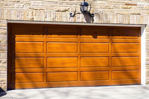 A classic, wooden garage door with a raised panel design.